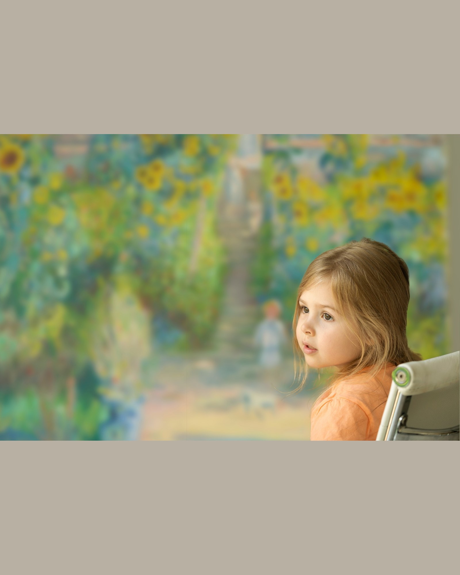 Leticia seated in the studio, with a blurred Monet-inspired painting in the background